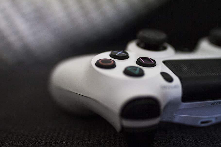 Close-up of a white gaming controller resting on a textured surface