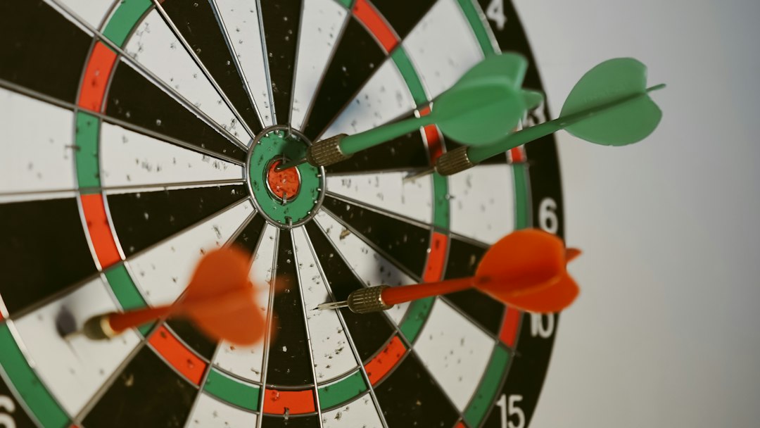 Close-up of darts hitting a dartboard, emphasizing goals and targets