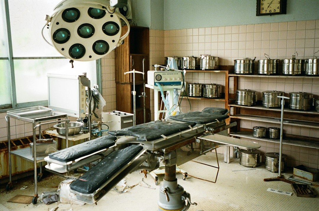 An abandoned surgical room with old equipment and an operation table.